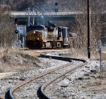 A blurry heavy tele shot of westbound CSX train L214 on their #2 track passing a restricting signal on #1 track lined for a train (probably the L206 local) to the "Switching Lead".
